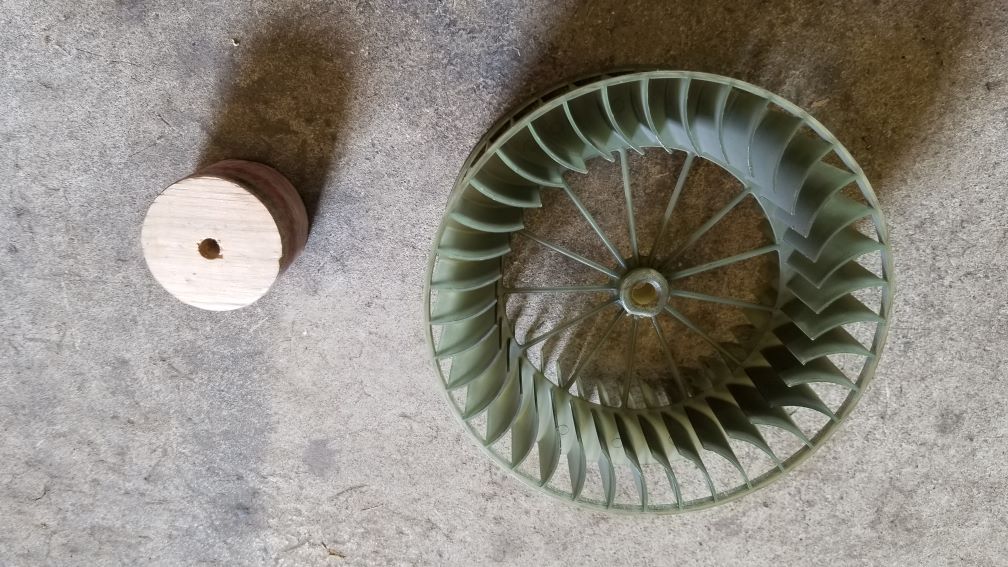 Plastic fan cylinder on the left, wooden wheel of ~2 inch diameter on the right